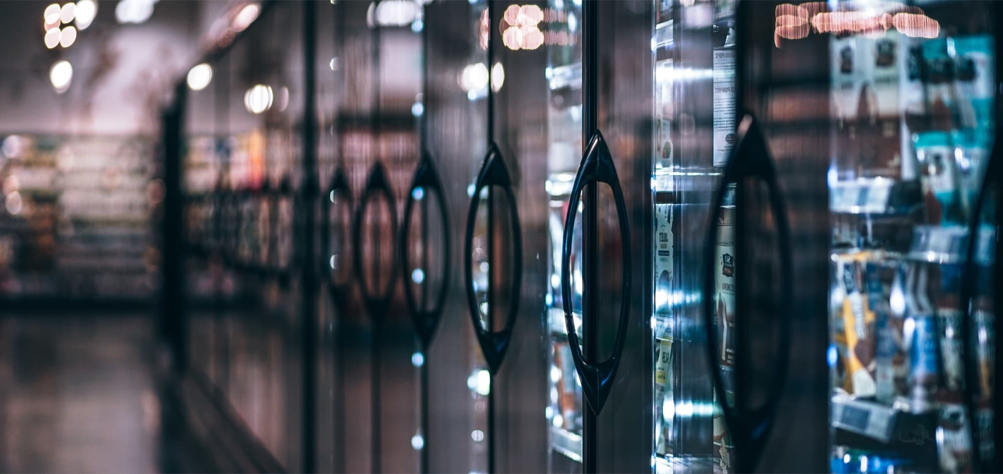 Commercial reach-in cooler doors in a grocery aisle